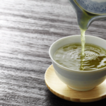 Cup of green tea with fresh leaves on wooden table | green tea benefits for weight loss