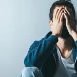 Person rubbing eyes while feeling tired at home | over-masturbation side effects on the eyes