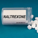 A bottle of LDN medication next to a medical report showing liver function test results and autoimmune support | low dose naltrexone side effects